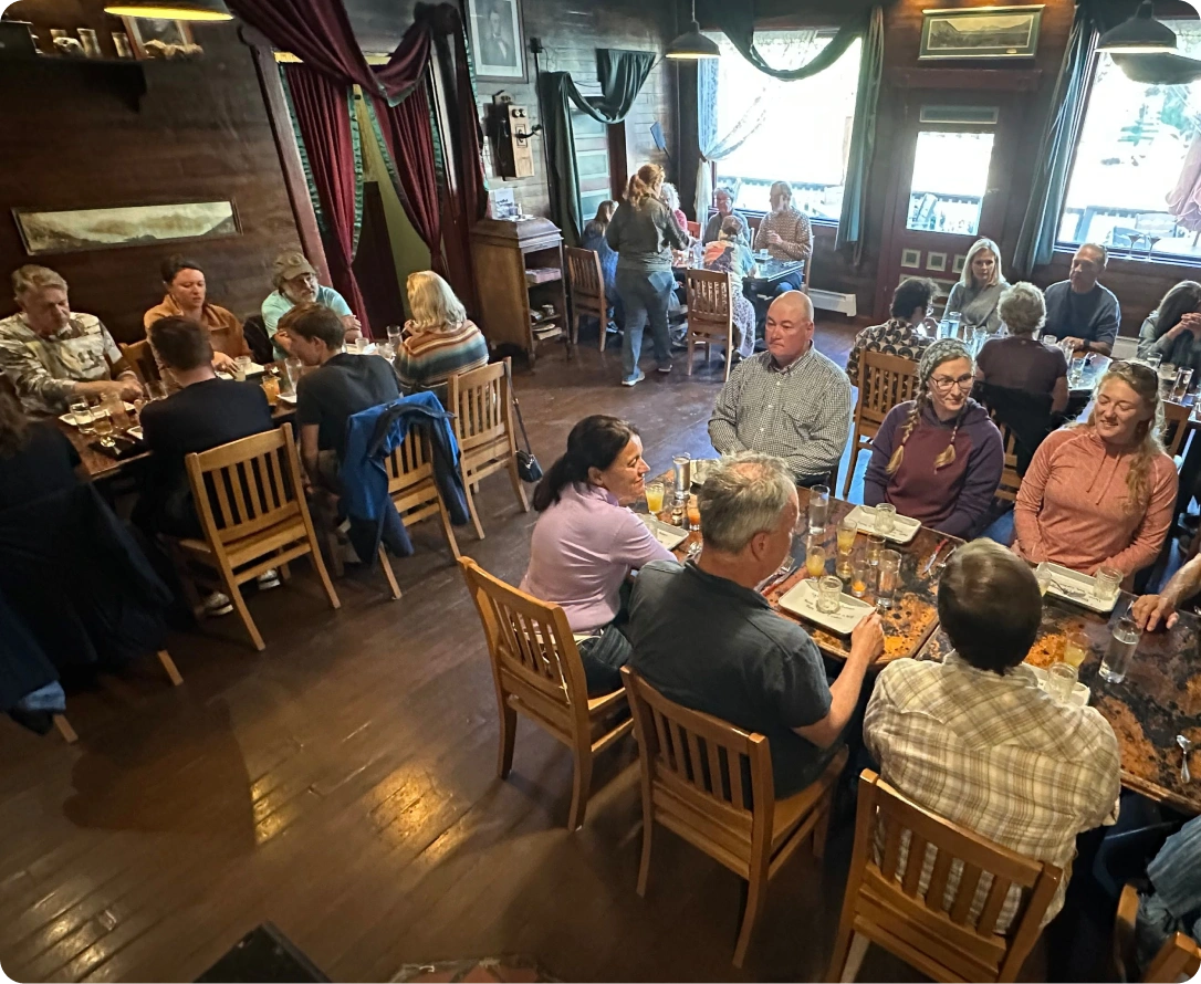 Interior of a bustling restaurant with patrons dining and a rustic decor